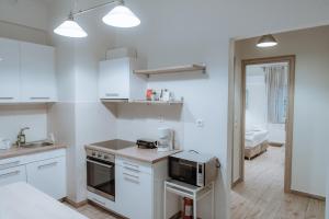 a kitchen with white cabinets and a microwave in it at Acropolis Museum Stylish Apartments in Athens +10 photos