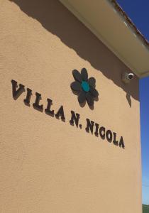 un panneau sur le côté d'un bâtiment avec une fleur dans l'établissement Villa Nonno Nicola, à Montenero di Bisaccia