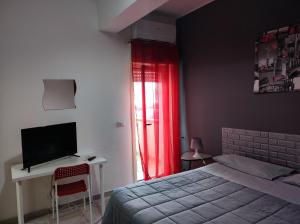 um quarto com uma cama e uma secretária com uma televisão em Bed and Breakfast Oasi em Reggio di Calabria