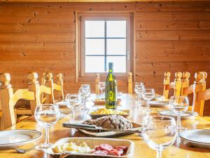 una mesa con una botella de vino y copas de vino en Chalet Naulaz by Interhome, en Val dʼIlliez