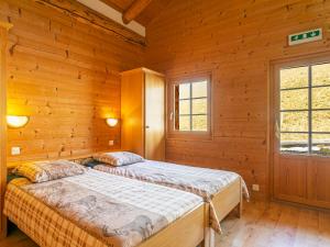 Dos camas en una habitación con paredes de madera. en Chalet Naulaz by Interhome, en Val dʼIlliez