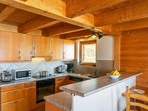 a kitchen with wooden cabinets and a counter top at Chalet Naulaz by Interhome in Val-d'Illiez