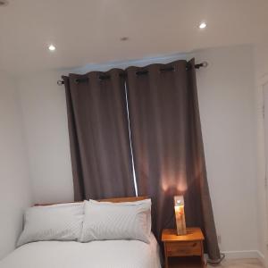 1 dormitorio con 1 cama con cortina negra en Dannifar Guest House en Londres