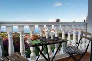 a table on a balcony with a view of the ocean at Geko Hotels in Los Llanillos