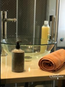 um lavatório de vidro com uma toalha e uma garrafa de sabão em Casa de Chanquete em Viana do Castelo