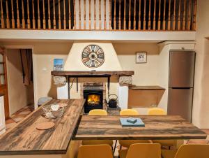 Millers Close Holiday Cottages في نيوكاسل: غرفة طعام كبيرة مع طاولة كبيرة ومدفأة