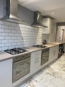 uma cozinha com electrodomésticos brancos e azulejos brancos em The Botley Road House em Oxford