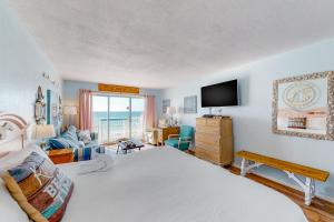 a bedroom with a bed and a tv and a couch at Islander W 603 in Fort Walton Beach