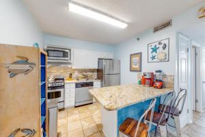 a kitchen with a counter and a refrigerator at Islander W 603 in Fort Walton Beach