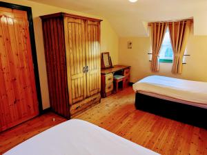 Millers Close Holiday Cottages في نيوكاسل: غرفة نوم بسريرين ومكتب مع مرآة