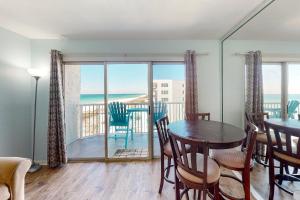 a dining room with a table and chairs and a balcony at Islander W 605 in Fort Walton Beach