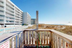 einen Holzbalkon mit einer Stange und einem Gebäude in der Unterkunft Islander W 703 in Fort Walton Beach