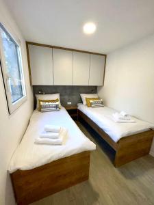 two beds in a small room with two towels at FJAKA luxury mobile home - Oaza Mira Camping Croatia in Drage