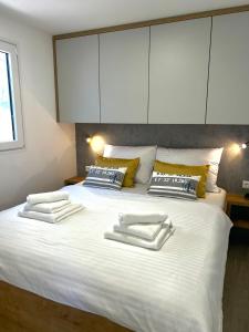 a large white bed with two towels on it at FJAKA luxury mobile home - Oaza Mira Camping Croatia in Drage