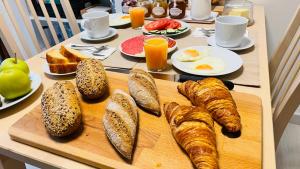 a table with a breakfast of bread and croissants at Casa Carlini Homestay in Getxo