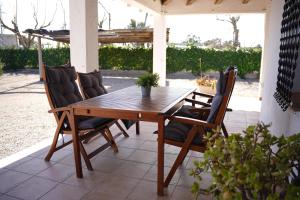 a wooden table and chairs on a patio at La Casilla in Deltebre