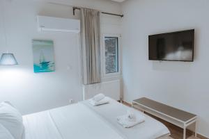 a white room with two beds and a flat screen tv at Acropolis Museum Stylish Apartments in Athens