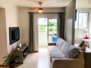 a living room with a couch and a tv at Apt 300 m da praia próximo ao Beto Carrero in Piçarras