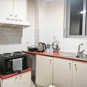 a kitchen with a microwave oven and a sink at Sweet studio in Pyrgos city near Olympia in Pyrgos