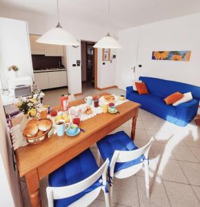 Una sala de estar con una mesa con comida y un sofá azul. en Arco Felix, en Arco