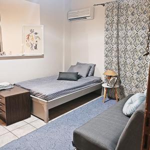 niewielka sypialnia z łóżkiem i kanapą w obiekcie Sweet studio in Pyrgos city near Olympia w mieście Pirgos