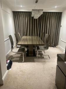 a dining room with a table and chairs at Lovely 3 bedroom house in Borehamwood . in Borehamwood