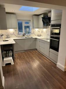 una cucina con elettrodomestici bianchi e pavimenti in legno di Lovely 3 bedroom house in Borehamwood . a Borehamwood