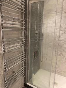 a shower with a glass door in a bathroom at Lovely 3 bedroom house in Borehamwood . in Borehamwood
