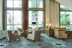 a lobby with chairs and a table and windows at Kansas City Marriott Downtown in Kansas City