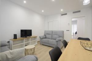 a living room with a couch and chairs and a table at Lightbooking Granada Materno in Granada