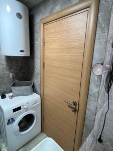 eine Holztür im Bad mit einer Waschmaschine in der Unterkunft Skopje LEKS apartment in Skopje