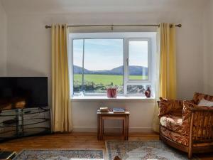 a living room with a large window and a couch at Church Cottage in Coupar Angus