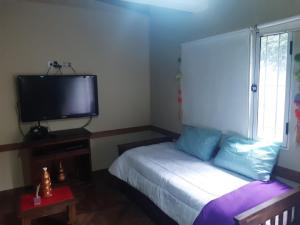 1 dormitorio con 1 cama y TV de pantalla plana en Depto en Tandil en Tandil