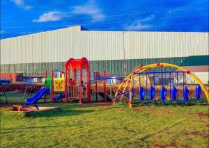 a playground with colorful equipment in a field at La Maison II- Two Bedroom in Tatu City, Nairobi in Nairobi