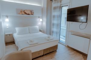 a small bedroom with a bed and a television at Acropolis Museum Stylish Apartments in Athens