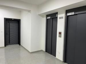 eine Reihe von drei schwarzen Türen in einem Gebäude in der Unterkunft Skopje LEKS apartment in Skopje