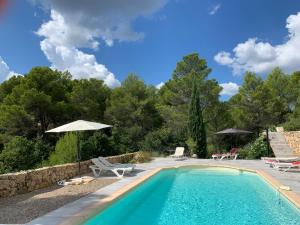 una piscina con sombrilla y sillas y un patio en Bramasole, en Tourtour