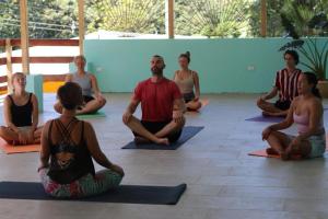 a group of people sitting in a yoga class at Planet B Hostel - Adults Only in Manuel Antonio