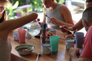 a group of people sitting around a table eating food at Planet B Hostel - Adults Only in Manuel Antonio