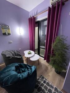 una sala de estar con paredes púrpuras y cortinas púrpuras. en Center Tirana Apartments, en Tirana