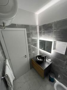 Baño pequeño con lavabo y espejo en Center Tirana Apartments, en Tirana