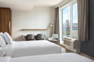 a hotel room with two beds and a window at TownePlace Suites by Marriott New York Long Island City in Queens +14 photos