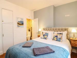 a bedroom with a bed with two towels on it at Seaside House in Weymouth