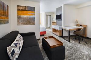 a living room with a couch and a desk in a hotel room at SpringHill Suites Houston Hobby Airport in Houston