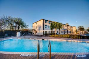 a large swimming pool in front of a building at Motel 6-San Antonio, TX - Sea World North in San Antonio