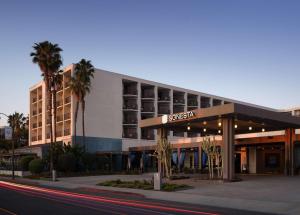 a hotel building with palm trees in front of it at Sonesta Redondo Beach and Marina in Redondo Beach