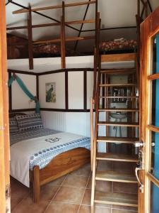 a bedroom with two bunk beds and a ladder at Cabañas Mountain River Lake Inn in Nueva California