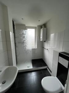 a bathroom with a shower and a toilet and a sink at Love Johann in Düsseldorf