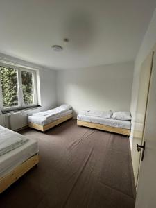 two beds in a room with two windows at Love Johann in Düsseldorf