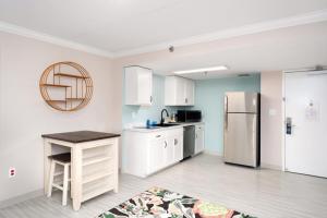 a kitchen with white cabinets and a refrigerator at Bella Vista Hotel & Suites in Lynchburg